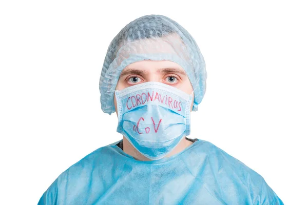Portrait of ill man in medical unifrom and protective mask with coronavirus nCoV text isolated on white background. Respiratory protection. Coronavirus concept — Stockfoto