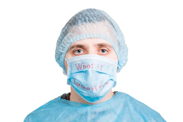 Portrait of young man wearing medical uniform and protective mask with what is coronavirus word isolated on white background. Coronavirus and health care concept — Stock Photo, Image