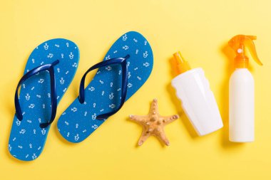 Sarı arka planda güneş kremi ya da vücut spreyi.