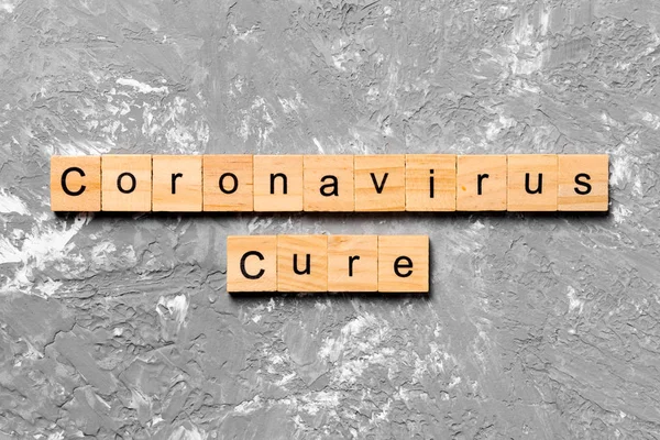 Coronavirus cura palabra escrita en bloque de madera. texto sobre tabla de madera para su diseño, Wuhan coronavirus cure, 2019-nCoV. concepto vista superior — Foto de Stock