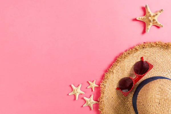 Sombrero de playa con conchas de mar sobre mesa de madera rosa. fondo de verano — Foto de Stock