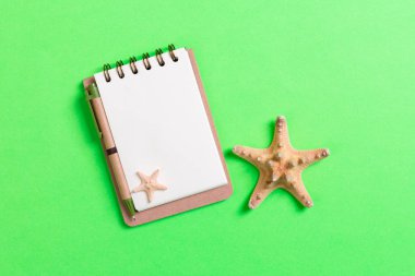 Yaz tatili için deniz kabuğu içeren boş bir defter.