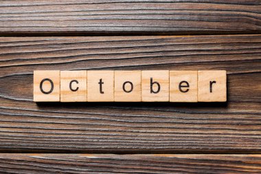 Tahta blokta Ekim kelimesi yazılı. Ekim metni ahşap masa üzerinde, üstteki görünüm konseptiniz için