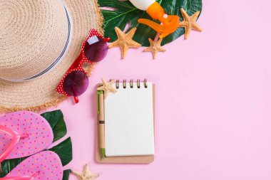 Hasır şapkalı plaj aksesuarları, güneş kremi şişesi ve deniz manzarası.