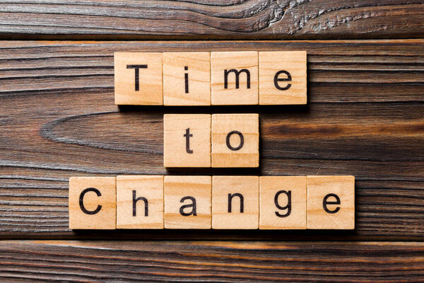 TIME TO CHANGE word written on wood block. ВРЕМЯ ИЗМЕНЕНИЯ текста на таблице, концепции