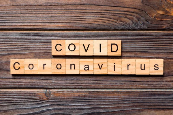 Inscripción COVID Coronavirus sobre fondo de madera. Palabra covid escrita en madera. texto sobre tabla de madera para su diseño, Wuhan Coronavirus, 2019-nCoV. concepto vista superior — Foto de Stock