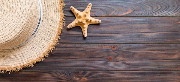 Straw hat and starfish On a dark banner wooden background. top view summer holiday concept with copy space