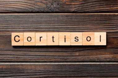 Tahta bloğa yazılmış kortizol kelimesi. Tahta masadaki kortizol metni. Üst görünüm konseptiniz için..