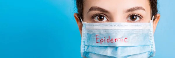 Portrait Young Woman Wearing Medical Mask Epidemic Word Blue Background — Stockfoto