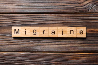 Migren sözcüğü ahşap blok üzerinde yazılı. Migren metin, tasarım, ahşap masanın kavramı.