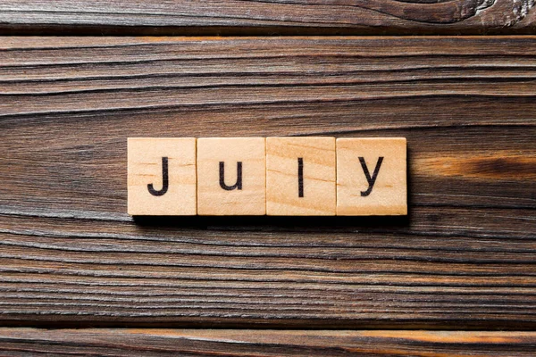 Λέξη Του Ιουλίου Γραμμένη Στο Ξύλο Ιούλιος Κείμενο Ξύλινο Τραπέζι — Φωτογραφία Αρχείου
