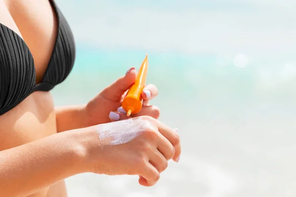 Chica Bronceada Está Usando Protector Solar Mano Playa — Foto de Stock