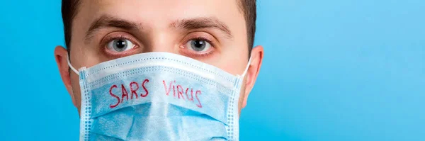 Portret Młodego Człowieka Masce Ochronnej Tekstem Wirusa Sars Niebieskim Tle — Zdjęcie stockowe