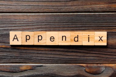 Apandisit kelimesi tahta bloğa yazılmış. Tablo üzerinde ek metin, konsept.