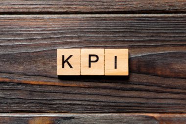Tahta blokta kpi kelimesi yazıyor. Masada kpi metni, konsept.