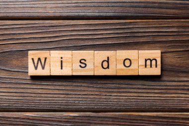 Tahta blokta yazan bilgelik kelimesi. Masada bilgelik metni, konsept.