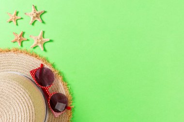 Kopya alanı ile yeşil arka plan üst görünümünde hasır şapka ve deniz kabukları ile Yaz tatili arka plan.