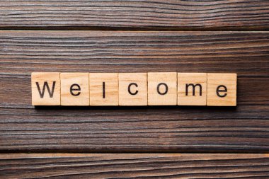 Ahşap blok üzerinde yazılı kelime hoş geldiniz. Hoş geldiniz metni masaya, kavram.