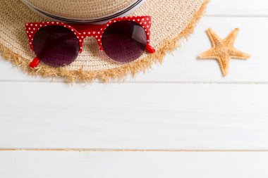 Hasır şapka, güneş gözlüğü ve denizyıldızı beyaz ahşap arka plan üzerinde. kopya alanı ile üst görünüm yaz tatili konsepti.