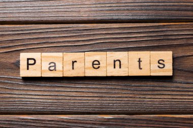 Ahşap blok üzerinde yazılı kelime anne. Ebeveynler için tasarım, ahşap masa üzerinde metin kavramı.