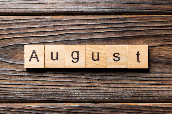 August word written on wood block. August text on wooden table for your desing, Top view concept.