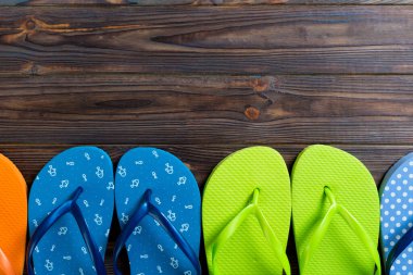 flip flop renkli sandalet bir sürü, ahşap arka plan üzerinde yaz tatili, kopya alanı üst görünümü.