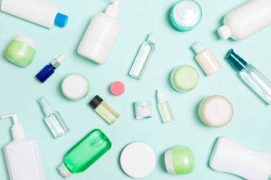 Plastik vücut bakımı şişesi grubu daire size tasarım için mavi arka plan boş alan kozmetik ürünleri ile kompozisyon yatıyordu. Beyaz Kozmetik Konteynerler, kopya alanı ile üst görünüm seti.