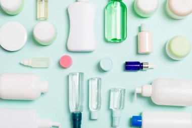 Plastik vücut bakımı şişesi grubu daire size tasarım için mavi arka plan boş alan kozmetik ürünleri ile kompozisyon yatıyordu. Beyaz Kozmetik Konteynerler, kopya alanı ile üst görünüm seti.