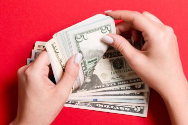 Para sayan kadın ellerinin en iyi görünümü. Renkli arka planda beş dolar banknotlar. İş kavramı.