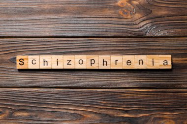 Tahta blokta yazan şizofreni kelimesi. Masada şizofreni metni, konsept.