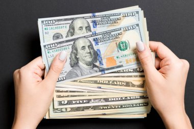 Renkli arka planda kadın elinde farklı dolar banknotlar üst görünümü. İş ve finans kavramı.