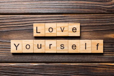 Tahta blokta yazılı olan sözüne bayıldım. Ahşap masanın üzerinde kendini sev, Top view konseptin için..