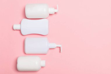 Beyaz Kozmetik kapları seti pembe arka plan üzerinde izole, kopya alanı ile üst görünümü. Tasarım için boş alana sahip plastik vücut bakım şişe kapları Grubu.