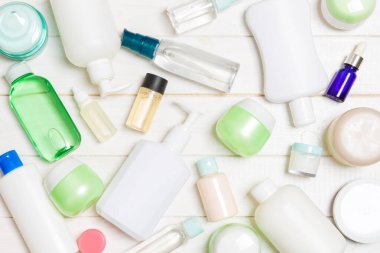 Plastik vücut bakım şişesi Grubu Düz tasarım için ahşap arka plan boş alan kozmetik ürünleri ile kompozisyon yatıyordu. Beyaz Kozmetik kapları seti, fotokopi alanı ile üst görünüm.