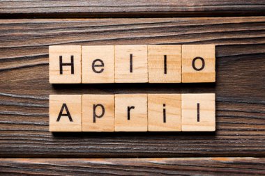 Merhaba Nisan kelimesi tahta blokta yazılı. Merhaba Nisan metni masa, konsept.