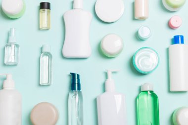 Plastik vücut bakımı şişesi grubu daire size tasarım için mavi arka plan boş alan kozmetik ürünleri ile kompozisyon yatıyordu. Beyaz Kozmetik Konteynerler, kopya alanı ile üst görünüm seti.