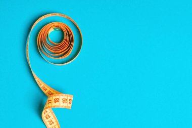 Tasarım için alan ile haddelenmiş bant ölçüsü. Mavi arka planda ince bel konseptinin üst görünümü.