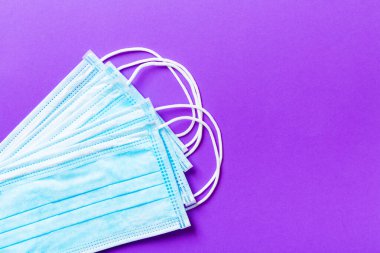 Mor arkaplandaki koruyucu tıbbi maskelerin üst görüntüsü. Ncov ve covid salgını. Salgın hastalık konsepti. Fotokopi ile sağlığınızı koruyun.