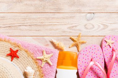 parmak arası terlik, hasır şapka, denizyıldızı, güneş kremi şişesi, ahşap arka plan üst görünümünde vücut losyon sprey . düz yatıyordu yaz plaj deniz aksesuarları arka plan, tatil konsepti.