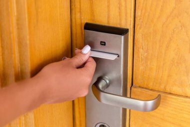 Elektronik kilitte anahtar kartı olan kadın el. Kadın el anahtarı kartı ve açık elektronik kilit kapı tutun.