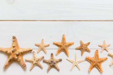 Beyaz ahşap masa üzerinde çeşitli deniz kabuğu ve denizyıldızı Düz yatıyordu, üst görünümü. Kopya alanı arka plan, yaz konsepti.