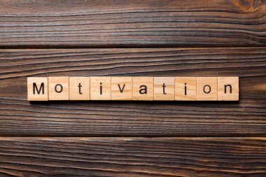 Motivasyon kelime ahşap blok üzerinde yazılı. Motivasyon metin, tasarım, ahşap masanın kavramı.