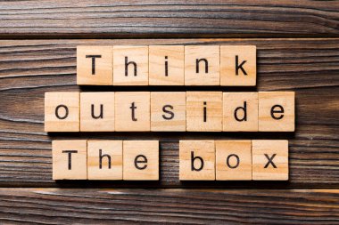 Tahta blokta yazan kutunun dışını düşün. Tahta masanın üstündeki kutu metninin dışında düşün. Top view konseptin için..