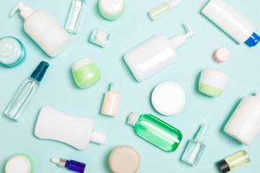 Plastik vücut bakımı şişesi grubu daire size tasarım için mavi arka plan boş alan kozmetik ürünleri ile kompozisyon yatıyordu. Beyaz Kozmetik Konteynerler, kopya alanı ile üst görünüm seti.