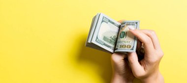 İş kadınının elleri renkli arka planda 100 dolarlık banknotları sayıyor. Maaş ve maaş kavramı kopyalama alanı ile. Yatırım kavramına en üst düzey bakış.