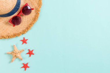 Kopya alanı ile mavi arka plan üst görünümünde hasır şapka ve deniz kabukları ile Yaz tatili arka plan.