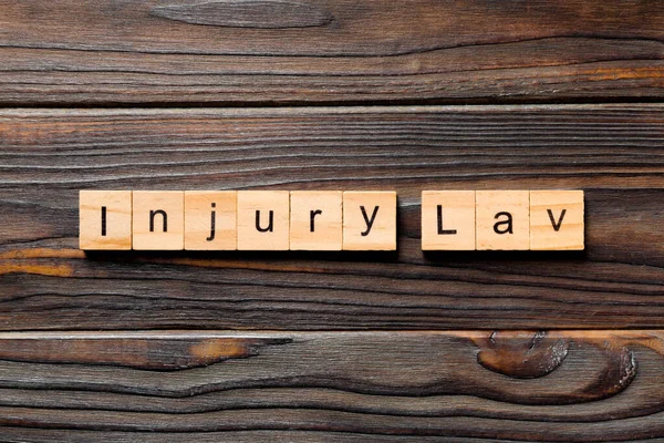 INJURY law word written on wood block. INJURY law text on table, concept.