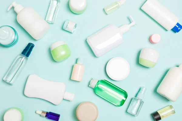 Plastik vücut bakımı şişesi grubu daire size tasarım için mavi arka plan boş alan kozmetik ürünleri ile kompozisyon yatıyordu. Beyaz Kozmetik Konteynerler, kopya alanı ile üst görünüm seti.