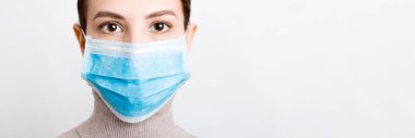 Beyaz arka planda tıbbi maske takan genç bir kadının portresi. Sağlığınızı koruyun. Coronavirus konsepti.
