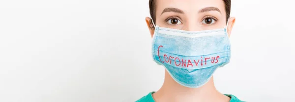 白い背景にコロナウイルスのテキストと医療用マスクの悲しい女性の肖像画 コロナウイルスの概念 呼吸器保護 — ストック写真